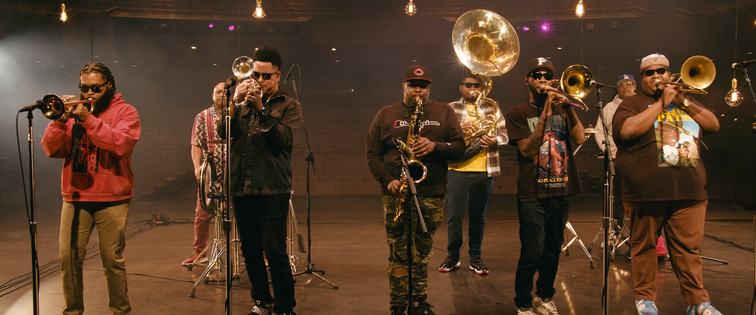 The Soul Rebels featured image. Six musicians play brass and woodwinds on a dimly lit stage.