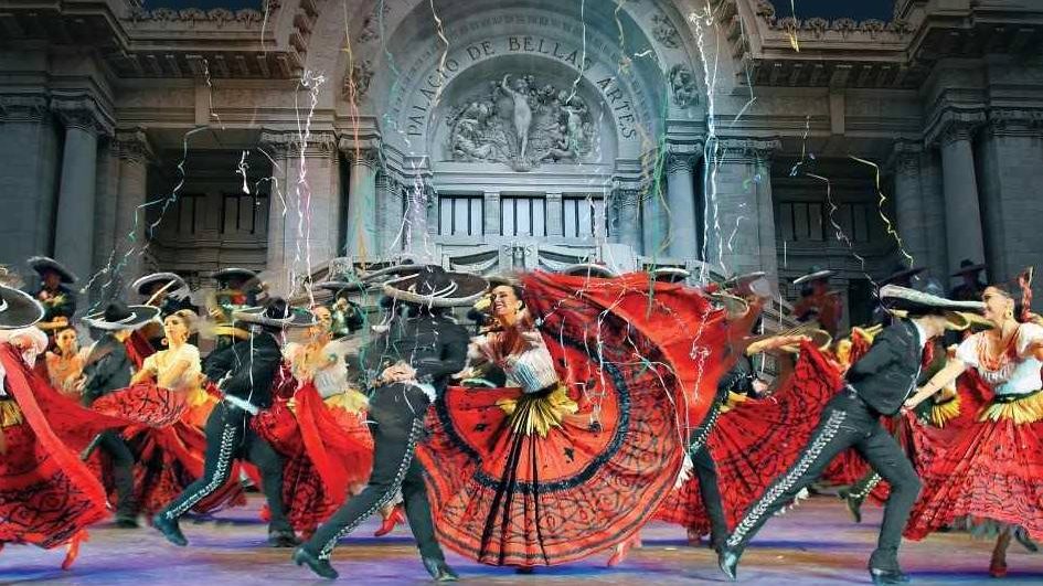 Vibrant folkloric dance performance in front of an ornate building, showcasing traditional costumes and dynamic movement.