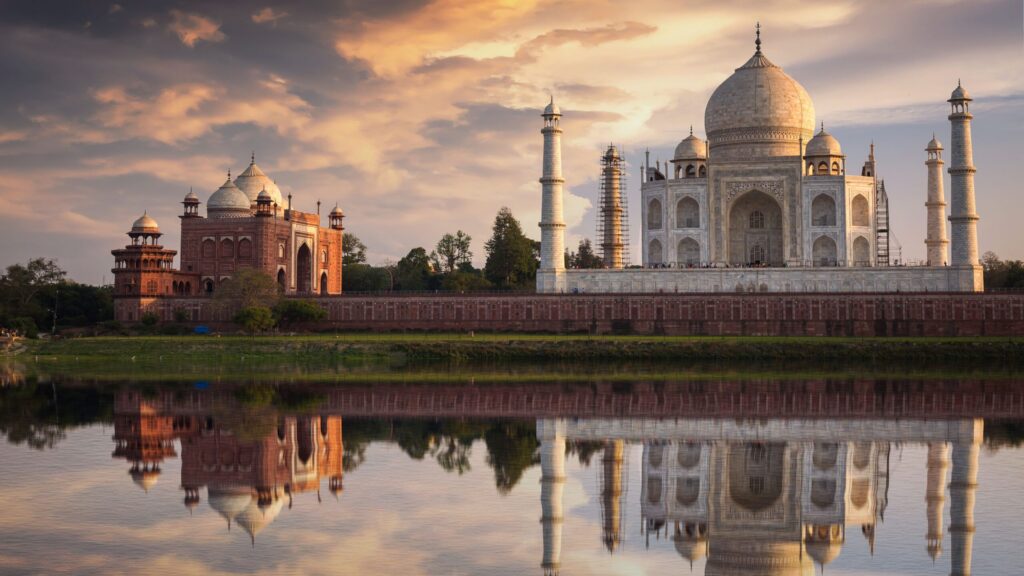 A serene sunset view of the taj mahal with its reflection in the yamuna river, showcasing the magnificent architectural beauty of this iconic mausoleum.
