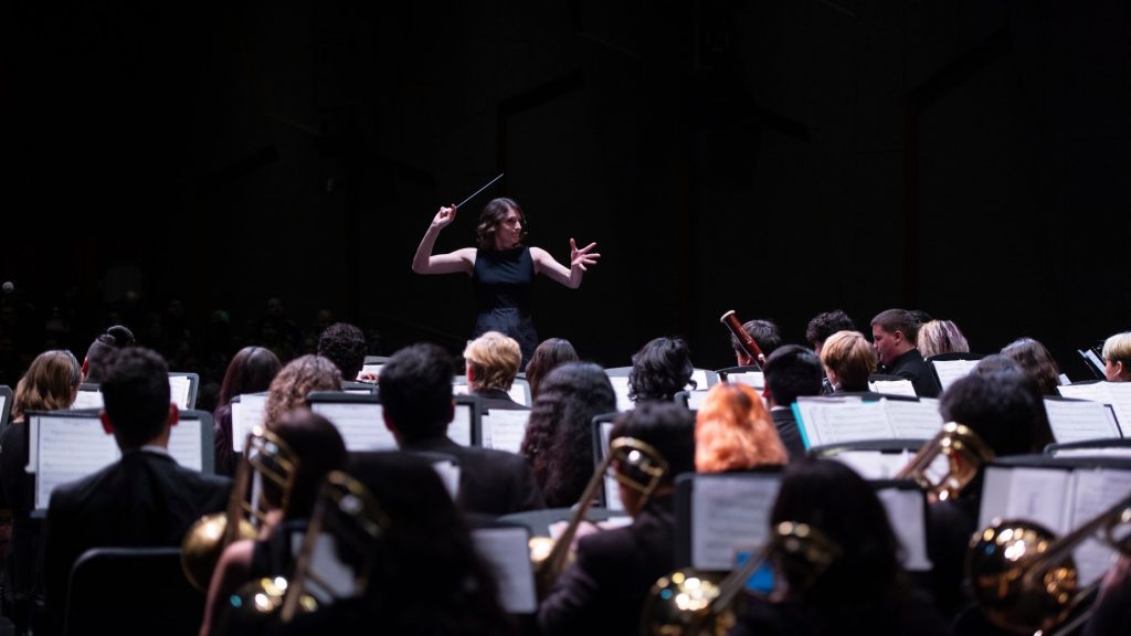 Conductor leading an engaged orchestra in performance.