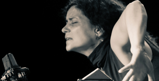 A passionate singer immersed in the emotion of the song, performing with a microphone in a black and white photograph.