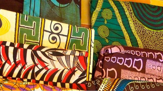 Vibrant and colorful african print fabrics neatly folded, showcasing intricate patterns and designs.