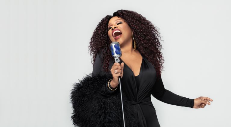 A passionate Chaka Khan belting out a tune into a vintage microphone, expressing emotion through her powerful performance.