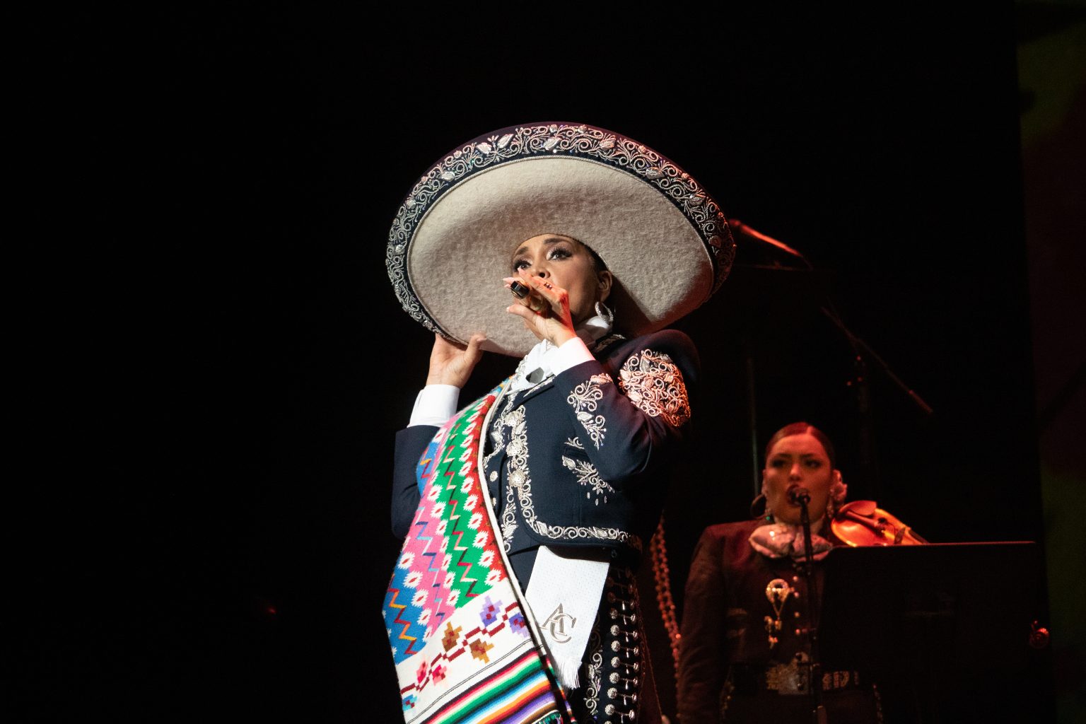 Aida Cuevas in ranchera outfit singing on stage