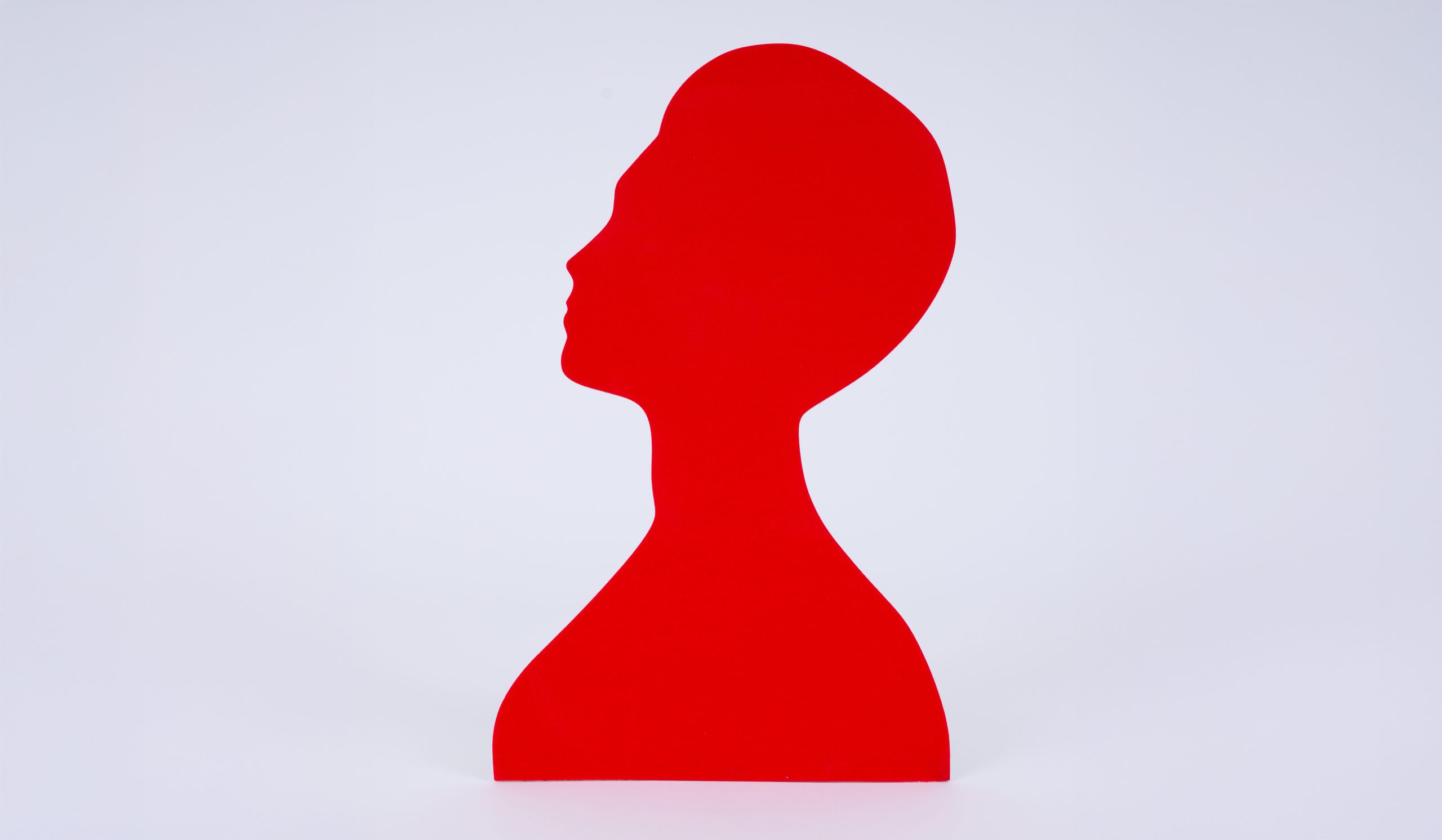 red silhouette of a woman posing with chin tilted upward.